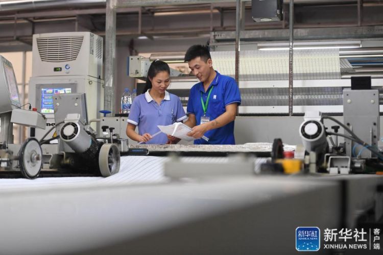 9月8日，来自定西的张刚刚（右）和马金芳夫妇在福建东龙针纺有限公司生产车间交流。新华社记者 林善传 摄