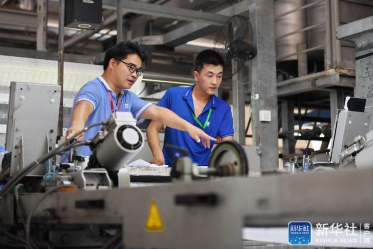 9月8日，来自定西的张刚刚（右）与福建东龙针纺有限公司染整厂生产部技术人员交流。新华社记者 林善传 摄